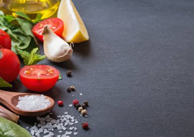 Fesleğen, zeytinyağı, tuz ve diğer malzemeler siyah taş zemin üzerine