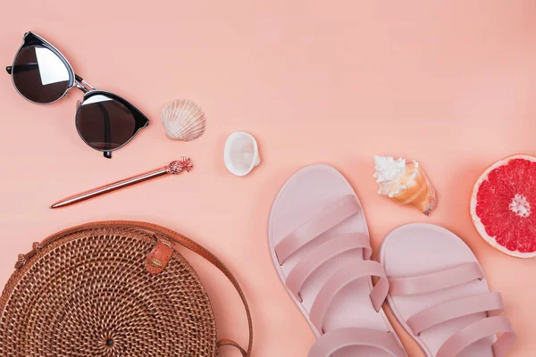 Creative composition with straw bag, sunglasses, pink sandals and other