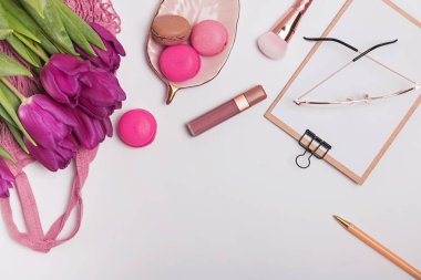 Mor laleler, beyaz masaya macarons ve sylish kadınsı aksesuarları
