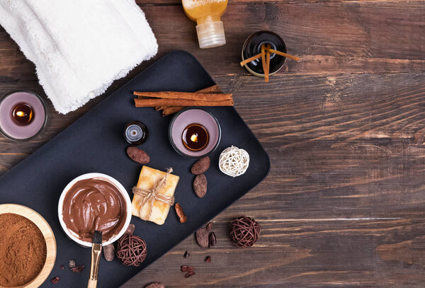 Chocolate spa set on the wooden background, top view.