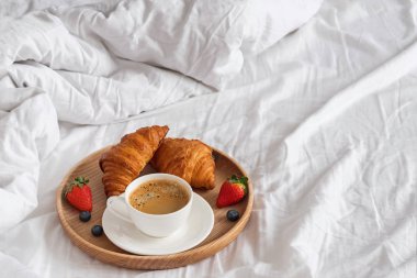 Kahve ve kruvasan üzerinde beyaz bedsheets yakın çekim