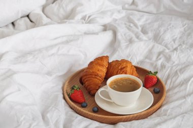 Kahve ve kruvasan üzerinde beyaz bedsheets yakın çekim