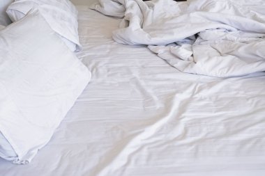 Beyaz bedlined ve yastıklar dağınık yatak.