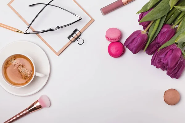 Stijlvolle vrouwelijke werkplek bovenaanzicht, voorjaar concept met paarse tulpen — Stockfoto