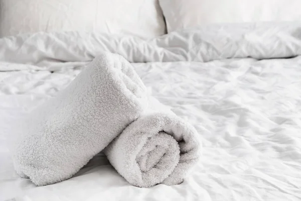 Чистые белые полотенца на белой кровати — стоковое фото