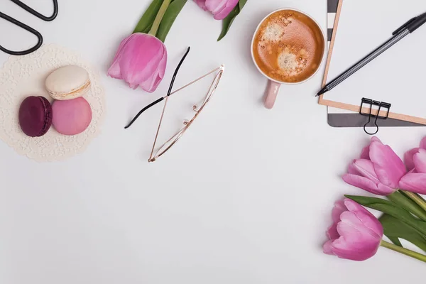 Bellissimi tulipani rosa, tazza di caffè e macaron sul tavolo bianco — Foto Stock