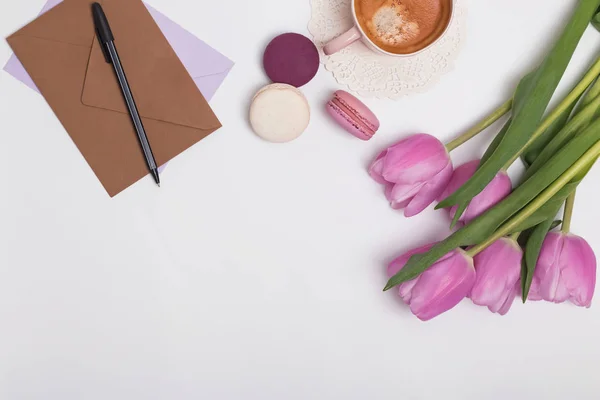 Tulpen, Macarons en enveloppen op de witte tafel — Stockfoto