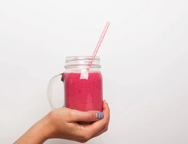 Mão das mulheres segurando um frasco de vidro com smoothie de baga — Fotografia de Stock