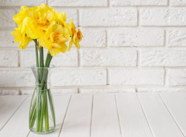 Beyaz tuğla duvar üzerinde güzel bahar çiçekleri Buket