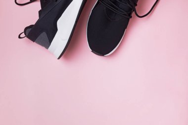 Pembe arka planda koşmak veya fitness için siyah spor ayakkabılar