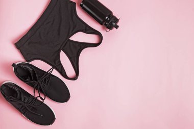 Pembe arkaplanda siyah renk fitness aksesuarları.