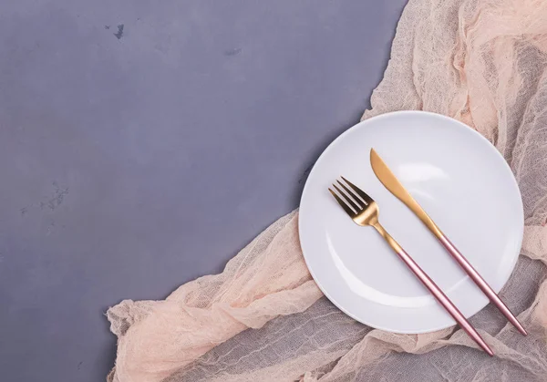 Placa blanca vacía y cubiertos de diseño moderno en la mesa de piedra gris —  Fotos de Stock