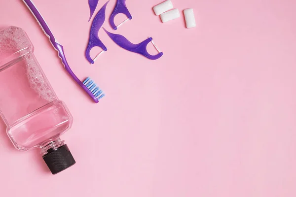 Accesorios para el cuidado dental sobre fondo rosa — Foto de Stock