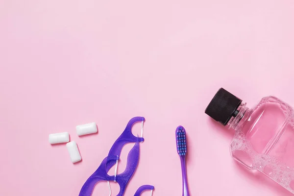 Accesorios para el cuidado dental sobre fondo rosa — Foto de Stock