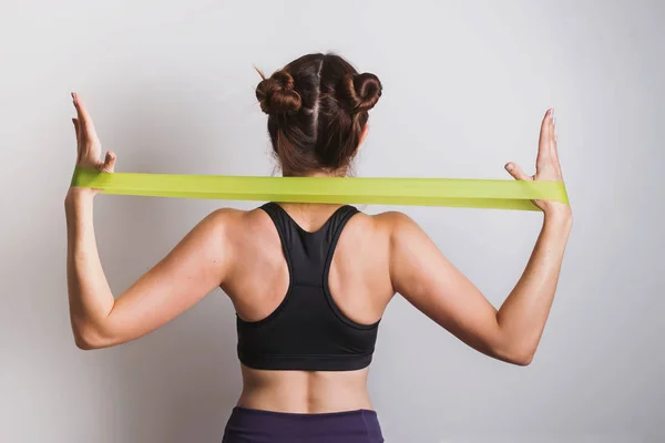 Young athletic woman doing exercises with fitness rubber band — Stock Photo, Image