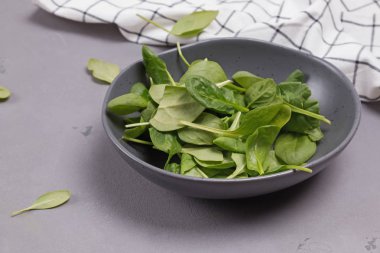 Bebek ıspanak gri taş arka plan üzerinde rustik bir kapta yaprakları