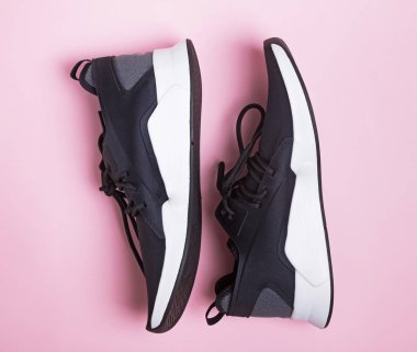 Pembe arka planda koşmak veya fitness için siyah spor ayakkabılar