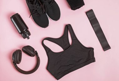 Pembe arkaplanda siyah renk fitness aksesuarları.