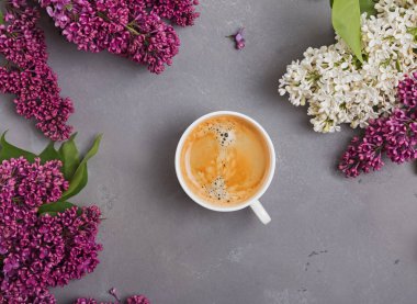 Güzel leylak çiçekleri ile masada kahve Fincan.