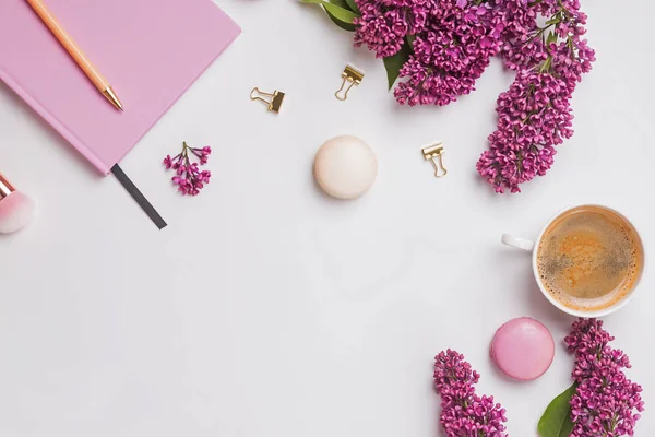 Kreatív kompozíció női kiegészítők, gyönyörű lila virágok, kávé és makaróni — Stock Fotó