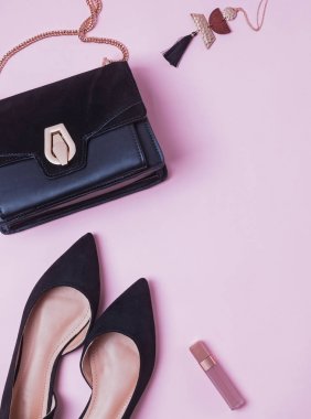 Şık kadınsı aksesuarlar düz pibk arka plan üzerinde yatıyordu