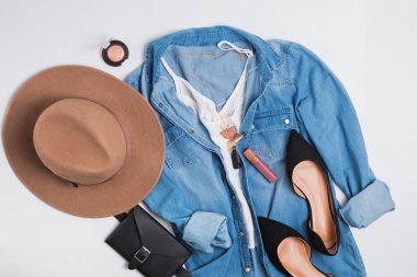 Denim gömlek, süet düz ayakkabı ve şapka ile modern şık kadınsı kıyafet