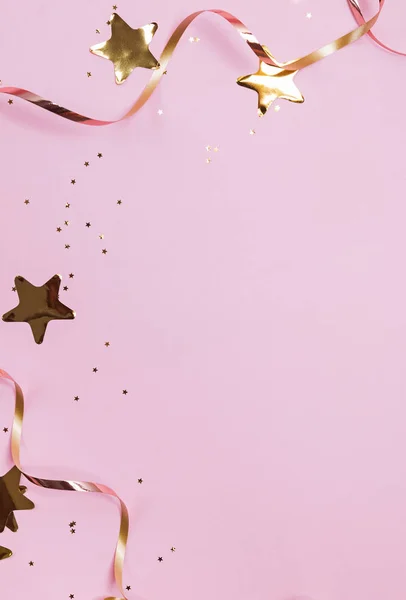 Конфетти в форме золотой декор звезды и ленты изолированы на розовом фоне пастель — стоковое фото