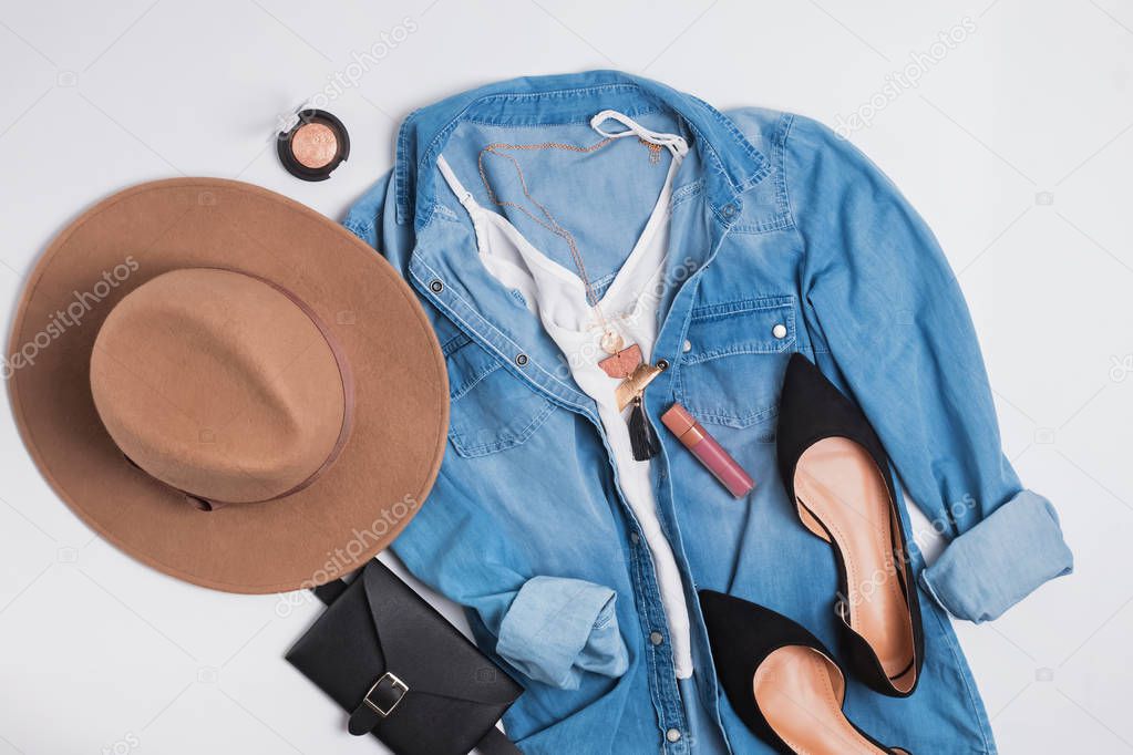 Modern stylish feminine outfit with denim shirt, suede flat shoes and hat