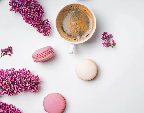 Kreative Frühlingskomposition mit Kaffee, Macarons und Fliederblüten — Stockfoto