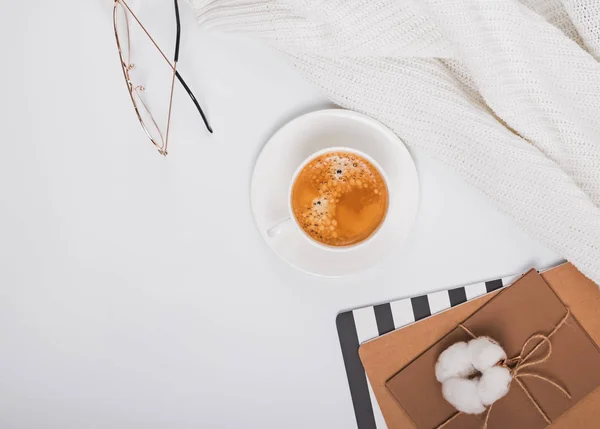 Café, vasos y bloc de notas en la mesa blanca . —  Fotos de Stock