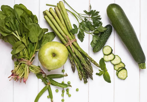 Groene groenten en kruiden op de witte houten achtergrond, bovenaanzicht — Stockfoto