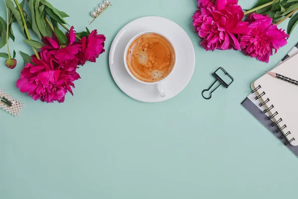 Creative frame with coffee, peonies and feminine accessories