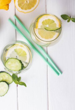 Beyaz ahşap masada nane, limon ve cucucmber ile aşılanmış su