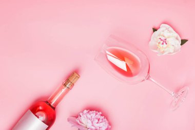 Pembe arka planda gül şarabı ve güzel şakayıklar.