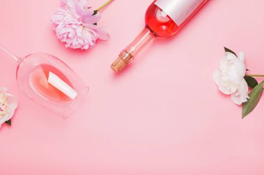 Pembe arka planda gül şarabı ve güzel şakayıklar.