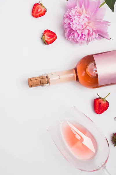 Creative summer flat lay with rose wine, delicious strawberries and beautiful peonies — Stock Photo, Image