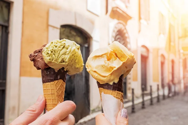 Twee handen close-up houden kegels met Italiaanse ijs gelato op de achtergrond van Rome Street — Stockfoto