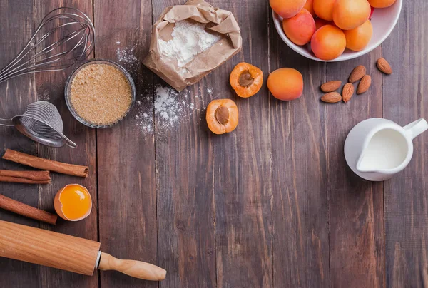 Інгредієнти та предмети для приготування пирога з абрикосами на дерев'яному фоні — стокове фото