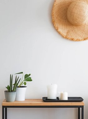Ayrıntılarda modern minimalist ışık iç. Küçük ahşap konsol üzerinde duvarda Hasır şapka