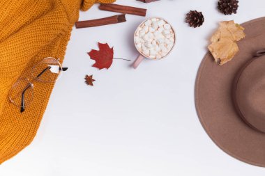 Sonbahar düz örme kazak, marshmallow ve sarı yaprakları ile kakao ile yatıyordu