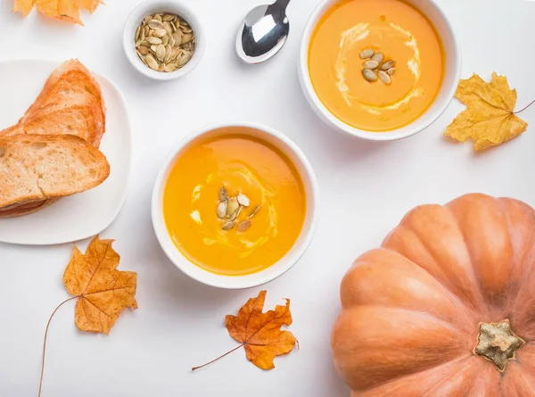 Deux bols de délicieuse soupe à la crème de citrouille sur la table blanche — Photo