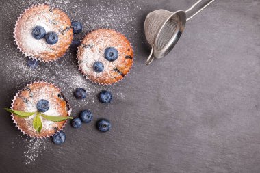 Lezzetli yaban mersinli kekler krema şekeri ile pudralanmış.