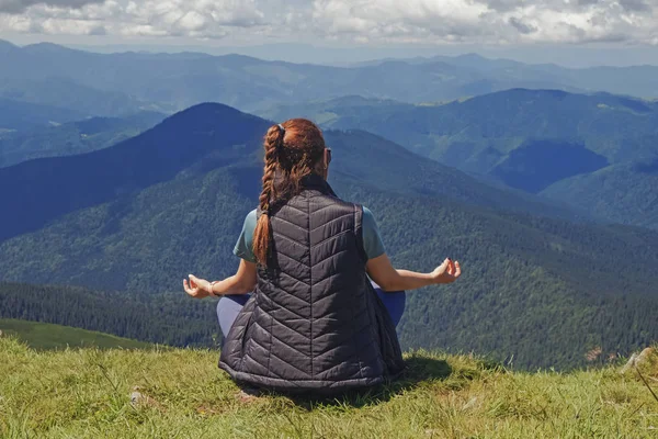 Perempuan dalam meditasi berpose duduk di puncak gunung — Stok Foto