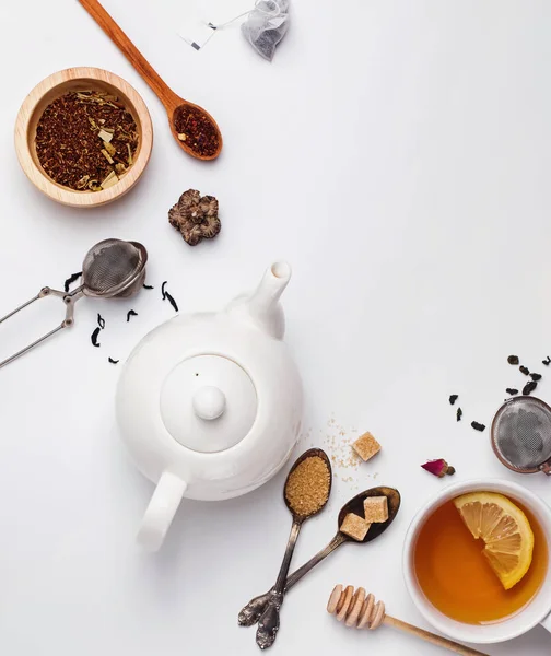 Kreative Komposition mit verschiedenen Teesorten, Zucker, Zitrone und anderem Zubehör zur Teezubereitung — Stockfoto