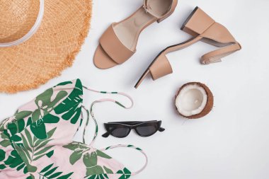 Beyaz arka planda elbise, sandalet, şapka ve diğer şık aksesuarlar