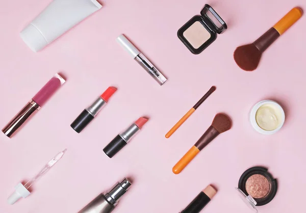 Cosméticos, pinceles y productos de maquillaje en el fondo rosa — Foto de Stock