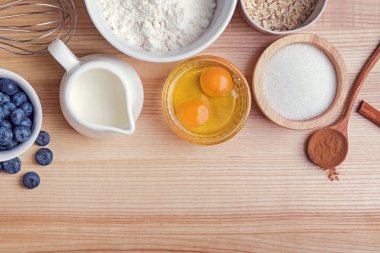 Ahşap masa üzerinde yaban mersini kekler hazırlık için Malzemeler, üst görünümü.