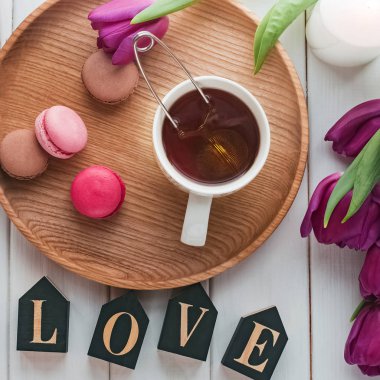 Çay, makarna, mor lale ve ahşap harflerle yaratıcı bahar kompozisyonu