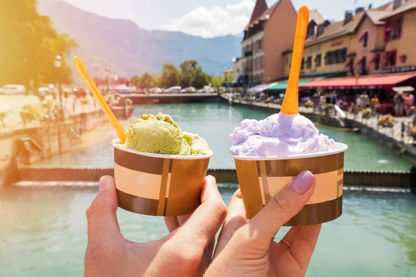 Man and woman hands holding sweet delicious ice-cream close-up on the background of European city — Stock Photo, Image