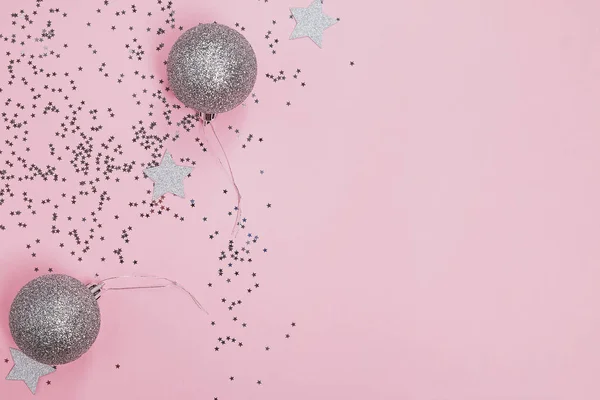 Star shaped silver confetti and Christmas decoration balls on pink background — Stock Photo, Image